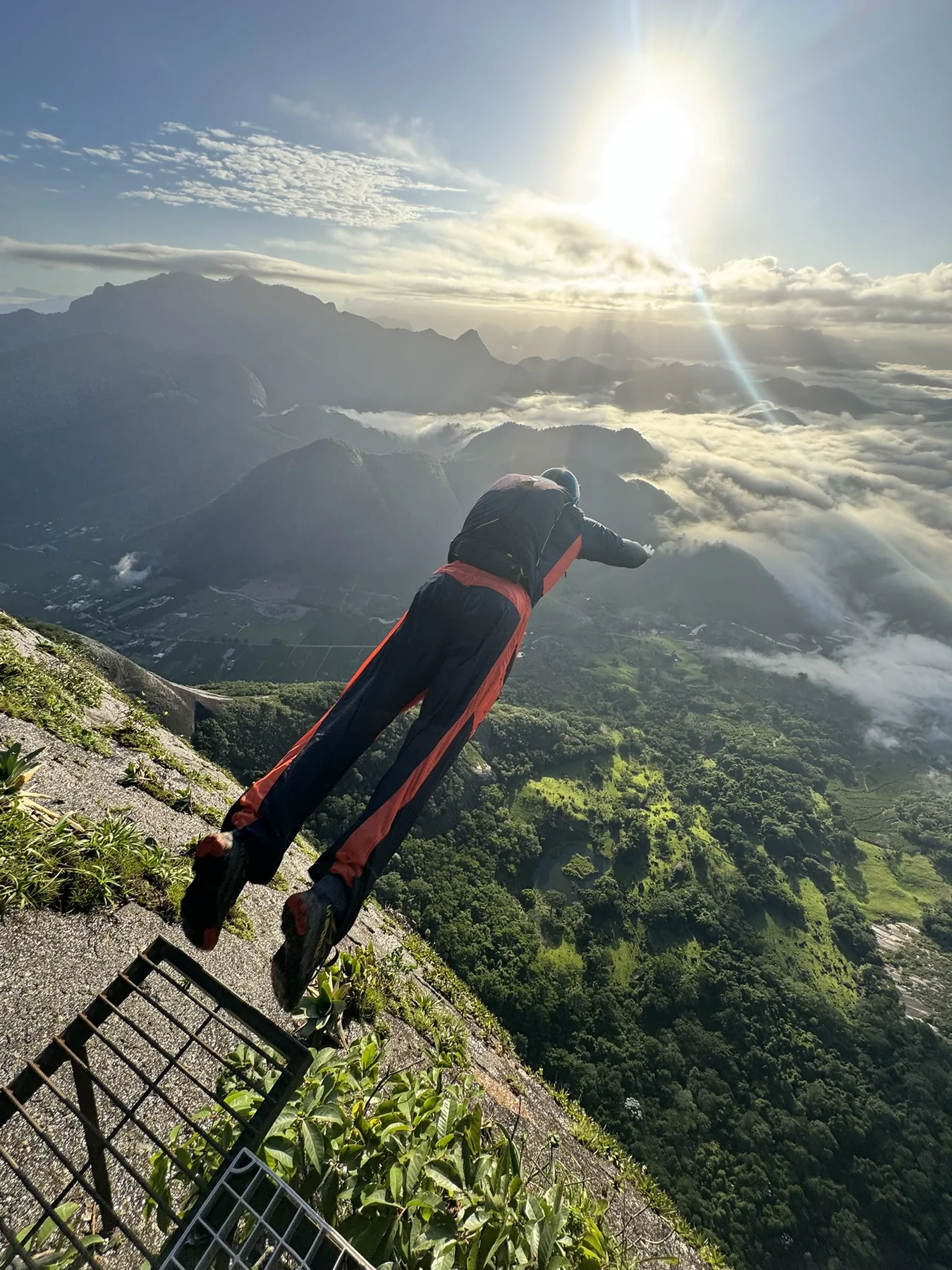 BASE jumper launching from an exit point into the sun