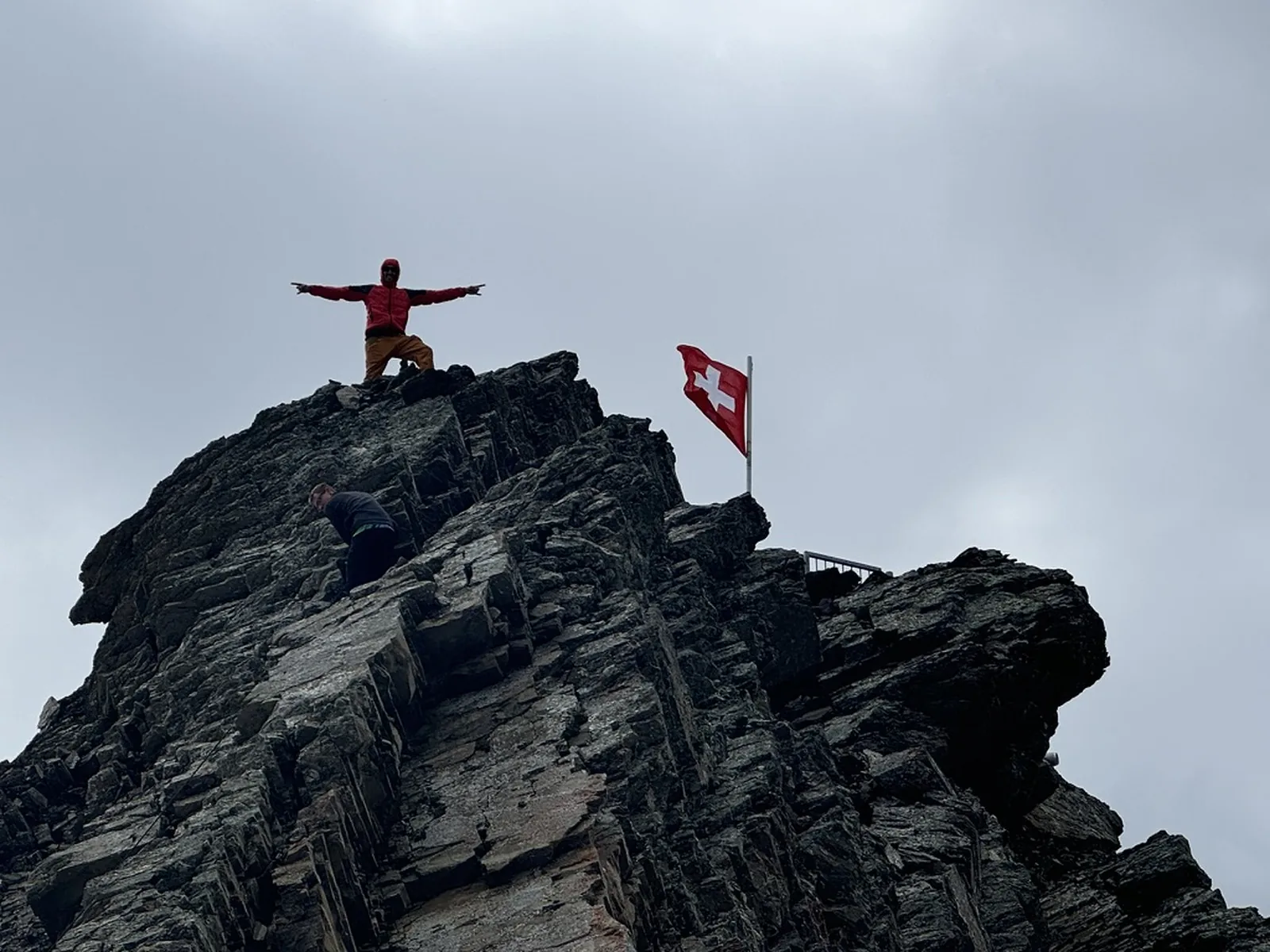 Standing on a summit beside the Swiss flag